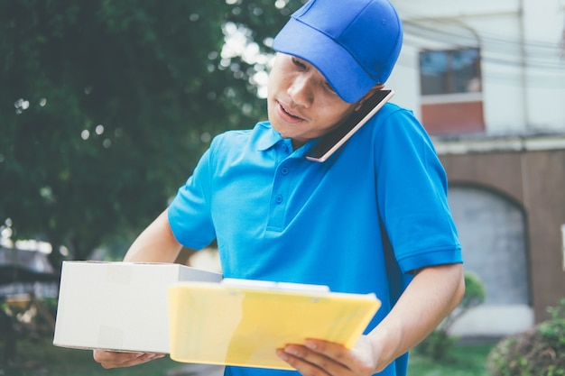 Delivery man talking customer by mobile phone.