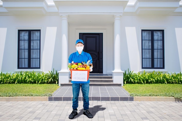 Delivery man wear medical mask while holding a box