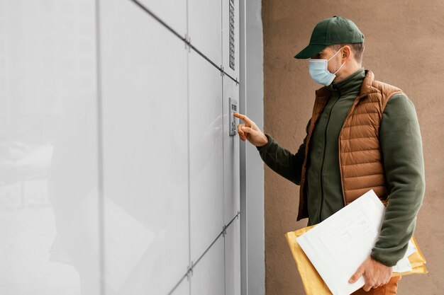 Uomo di consegna che indossa la maschera durante la consegna della vista laterale