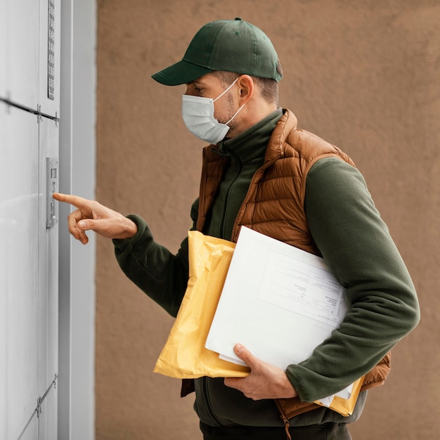 Delivery man wearing mask while delivering side view