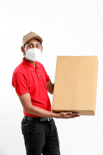 Доставка человек в медицинской маске и держать коробку в руках. Курьером. концепция безопасной доставки.