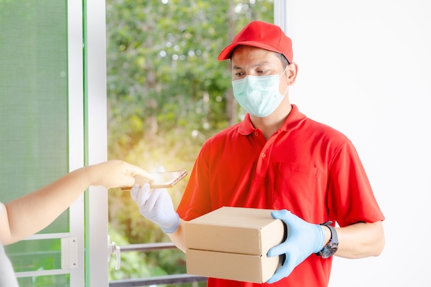 A delivery man wearing a red dress holds a parcel box.