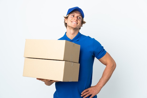 Delivery man over white posing with arms at hip and smiling