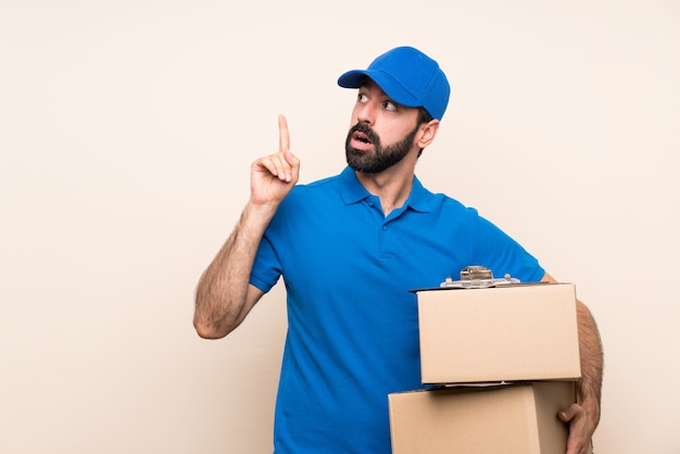 Delivery man with beard thinking an idea pointing the finger up