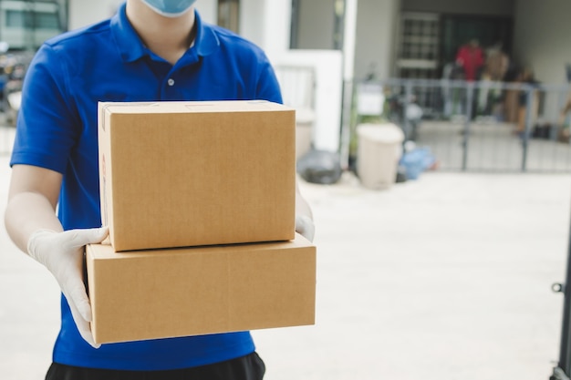 Delivery man with face mask holding boxes