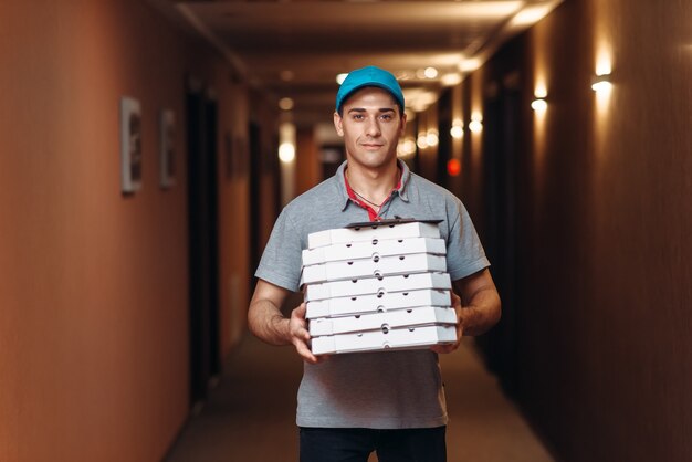 Delivery man with fresh pizza in carton boxes