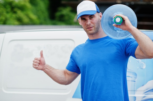 Photo delivery men in front cargo van delivering bottles of water and show thumb up.