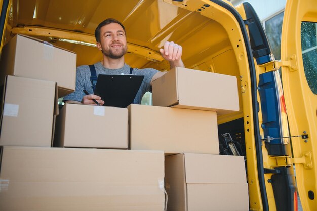 Delivery men unloading moving boxes from car