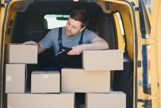 Delivery men unloading moving boxes from car