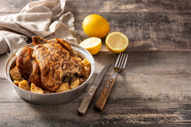 Delivery roasted chicken with potatoes on wooden table