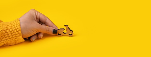 노란색 배경 위에 손에 배달 스쿠터, 텍스트를위한 공간이있는 파노라마 모형