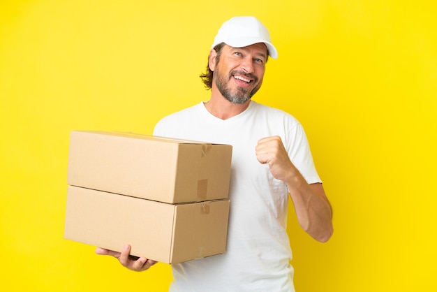 Delivery senior dutch man isolated on yellow background celebrating a victory