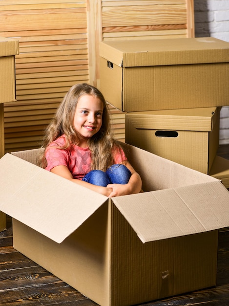 Delivery service. Box package and storage. Small child prepare for relocation. Big storage space. Relocating family stressful for kids. Kid girl relocating boxes background. Relocating concept.