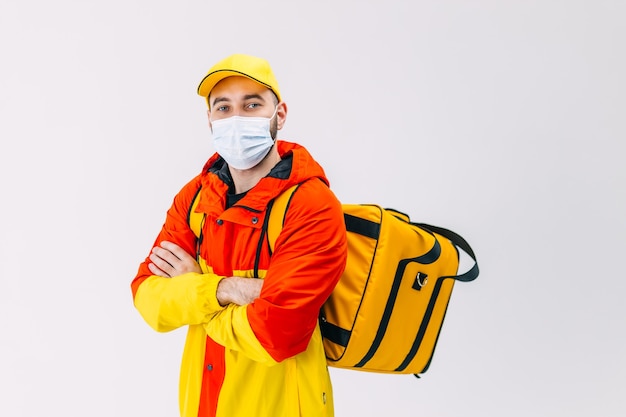 Impiegato del servizio di consegna in un berretto giallo uniforme borsa termica per alimenti zaino lavoro corriere in quarantena covid19
