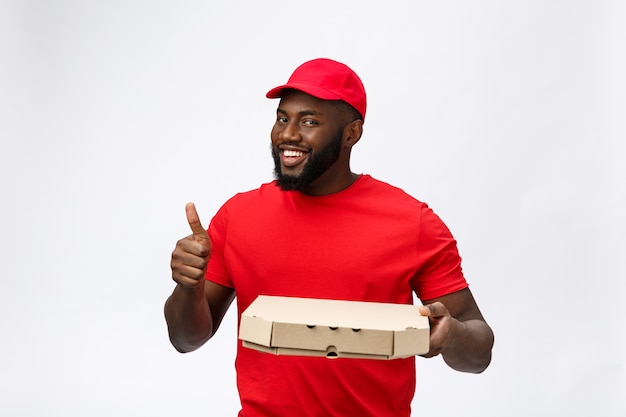 Delivery service - Portrait of Happy African American delivery man holding a pizza box package and showing thumbs up.  