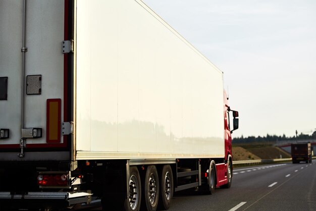 Delivery and shipping of goods by semitrailer trucks The trucks drive on the road with containers of cargo They are involved in the export and import of products for the global market