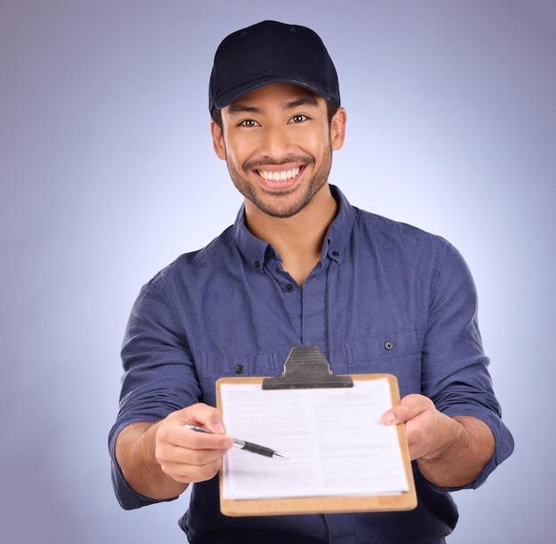 Delivery signature and portrait of Asian man with paperwork isolated on a studio background Happy showing and courier asking to sign a document for approval of a service import or package