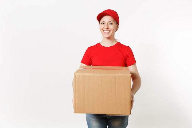 Delivery smiling woman in red uniform isolated on white background. Female in cap, t-shirt, jeans working as courier or dealer holding cardboard box. Receiving package. Copy space for advertisement.