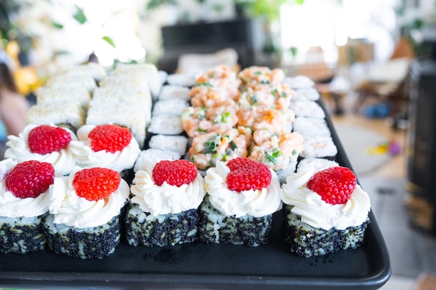 delivery of sushi and rolls set is hold in hand in the interior modern kitchen of house