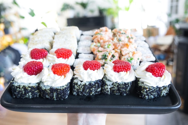 delivery of sushi and rolls set is hold in hand in the interior modern kitchen of house
