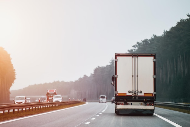 Delivery truck on the Europe highway Semitruck with cargo trailer driving at the tunnel Fast moving truck Lorry driver rides his modern truck