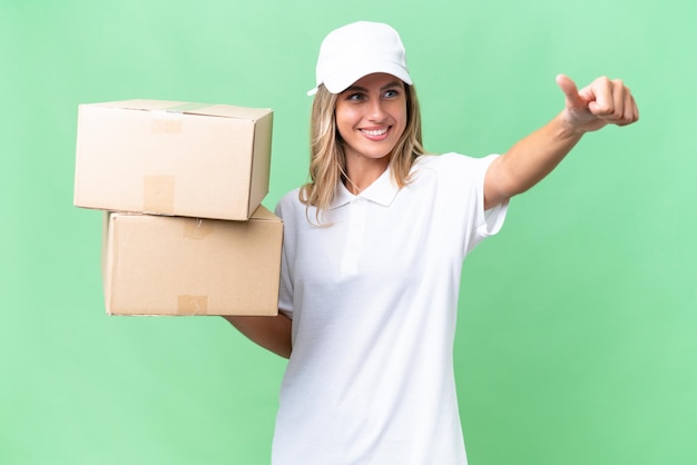 Delivery Uruguayan woman over isolated background giving a thumbs up gesture