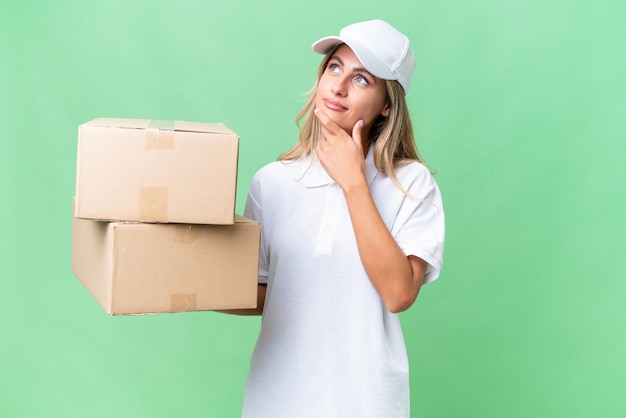 Delivery Uruguayan woman over isolated background having doubts