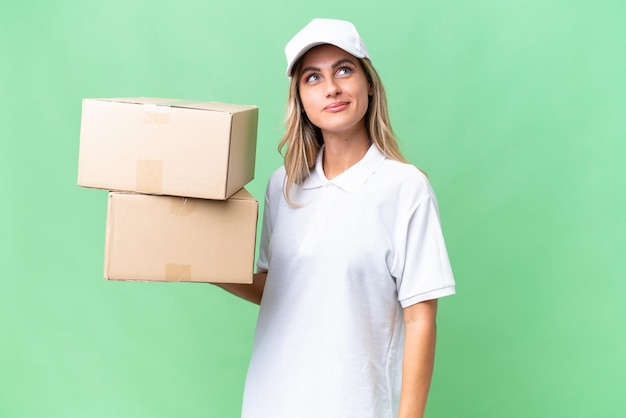 Delivery Uruguayan woman over isolated background and looking up