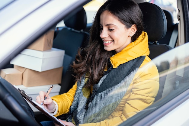 Delivery woman in car with package