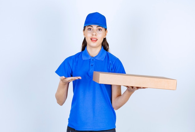 Delivery woman employee in uniform holding craft paper box .