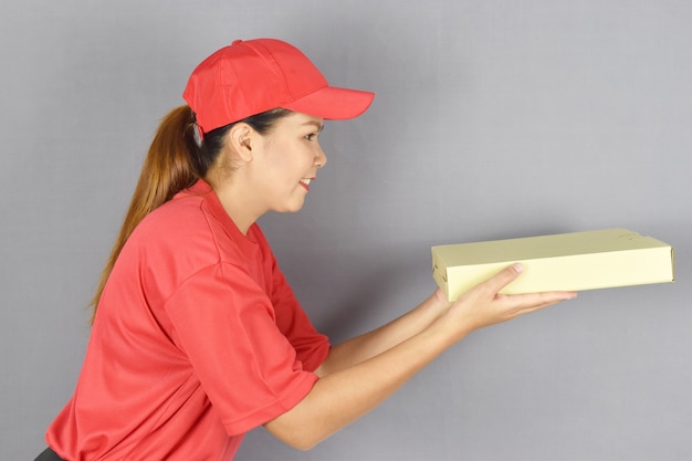 Женщина доставки, держащая коробку для пиццы на сером