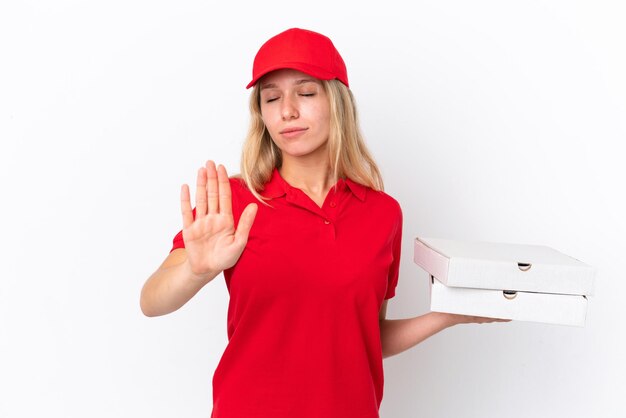 Женщина-доставщик, держащая пиццу, изолированную на белом фоне, делает стоп-жест и разочарована