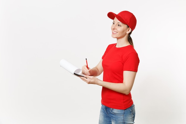 Donna di consegna in uniforme rossa isolata su fondo bianco. donna in berretto, t-shirt, jeans che lavora come corriere o rivenditore, penna in mano, appunti con documento di carta, con foglio vuoto vuoto. copia spazio.