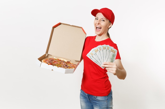 Delivery woman in red uniform isolated on white background. Female in cap, t-shirt, jeans working as courier holding italian pizza in cardboard flatbox, bundle of dollars, cash money . Copy space.