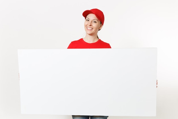 Женщина-доставщик в красной форме, изолированные на белом фоне. Женский курьер в кепке, футболке, джинсах держит большой белый пустой рекламный щит. Скопируйте космическую рекламу. Место для текста или изображения. Рекламная площадка