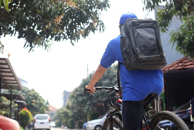 deliveryman bring packages on bag riding bicycle to send package to customer.