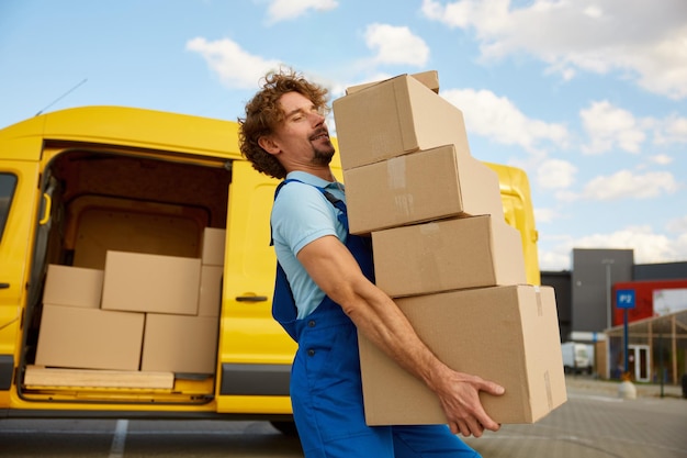 deliveryman carrying pile of cardboard boxes