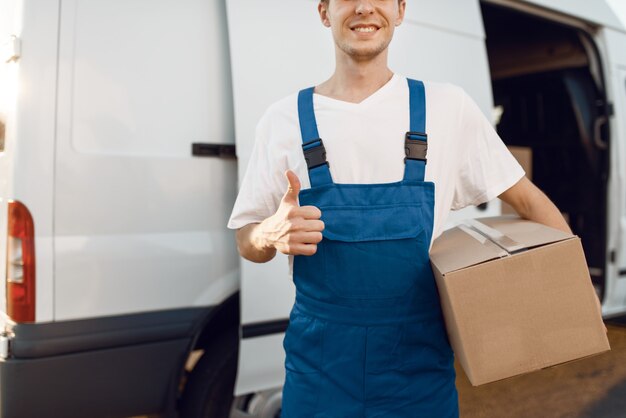 Deliveryman in uniform shows thumbs up, delivery