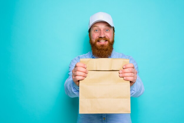 Deliveryman with happy expression is ready to deliver a food package