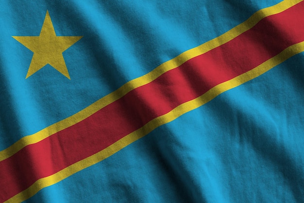 Democratic Republic of the Congo flag with big folds waving close up under the studio light indoors The official symbols and colors in banner