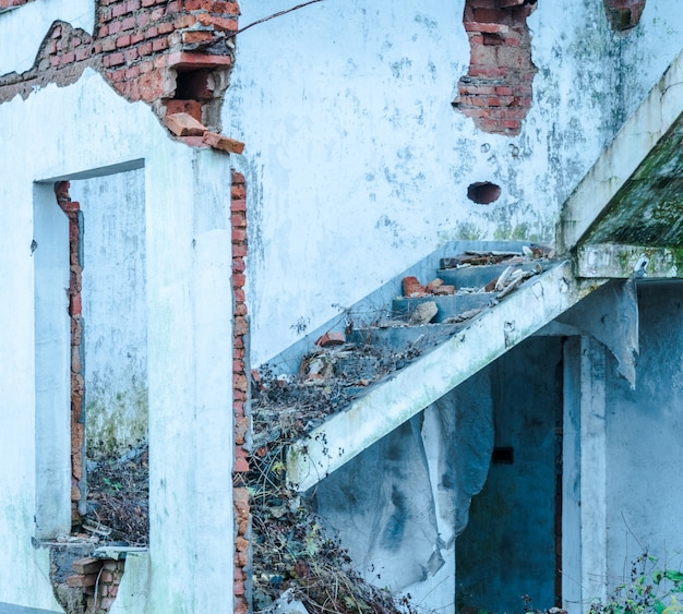 Demolished half of the dilapidated house brick wall