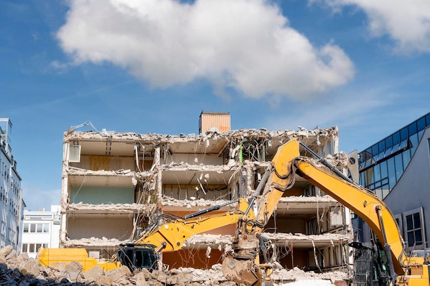 Demolition of building excavator breaks old house making space
for the construction of a new houses