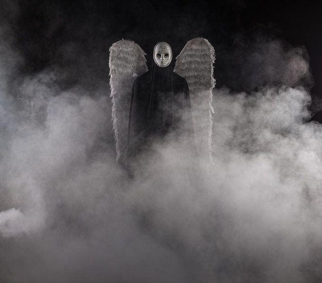 Photo demon angel with white wings on a black background