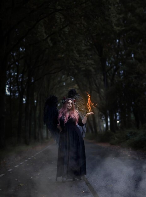Foto ragazza demone con il fuoco in mano