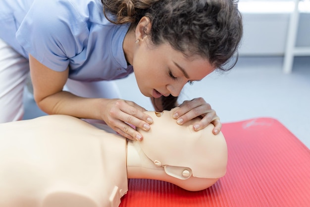 수업에서 CPR 인형에 대한 CPR 심폐 소생술 교육 의료 절차 시연 학생들이 환자를 구하는 방법을 배우고 있습니다.안전한 삶의 개념을 위한 응급처치