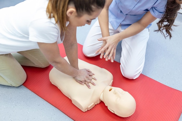 수업에서 CPR 인형에 대한 CPR 심폐 소생술 교육 의료 절차 시연의사와 간호사 학생들이 환자를 구출하는 방법을 배우고 있습니다.안전한 삶의 개념을 위한 응급처치