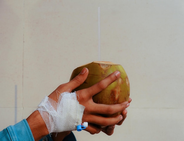 Photo dengue treatment food coconut water in a patient hand