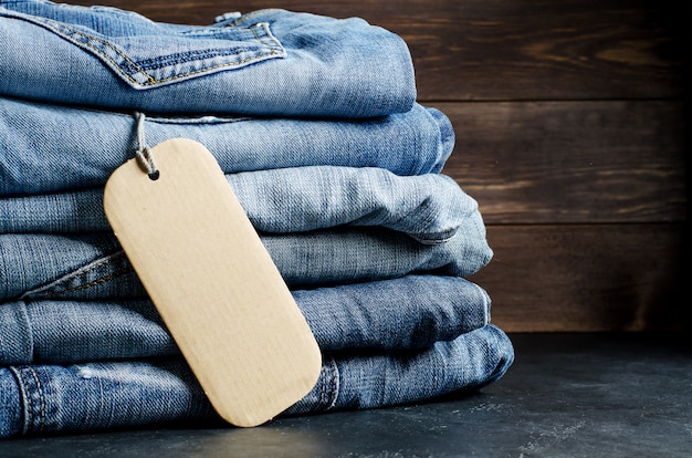 Photo denim. blue jeans on black background. label for writing text. copy space. the concept of selling goods in the store.