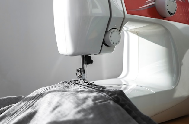 Denim cloth on sewing machine close up small business concept