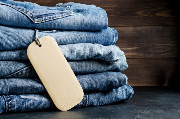 Denim. Jeans op zwarte achtergrond. Label voor het schrijven van tekst. Kopieer ruimte. Het concept van het verkopen van goederen in de winkel.